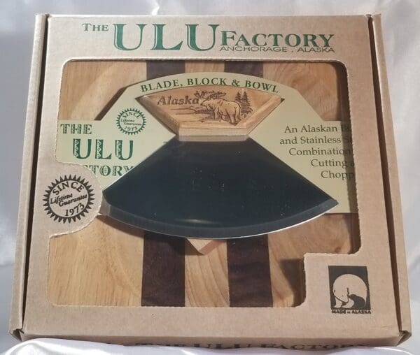The 6 1/2" Bowl with 5" Ulu & Display Stand factory's wooden cutting board.