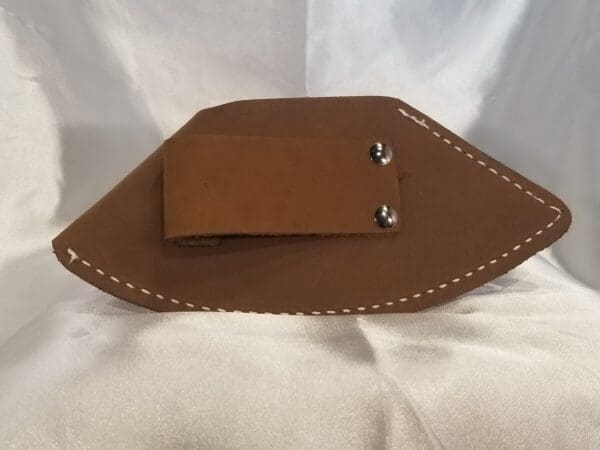 A brown leather holster with a white stitch on it.