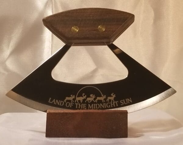 A wooden plaque with the words land of the midnight sun engraved on it.
