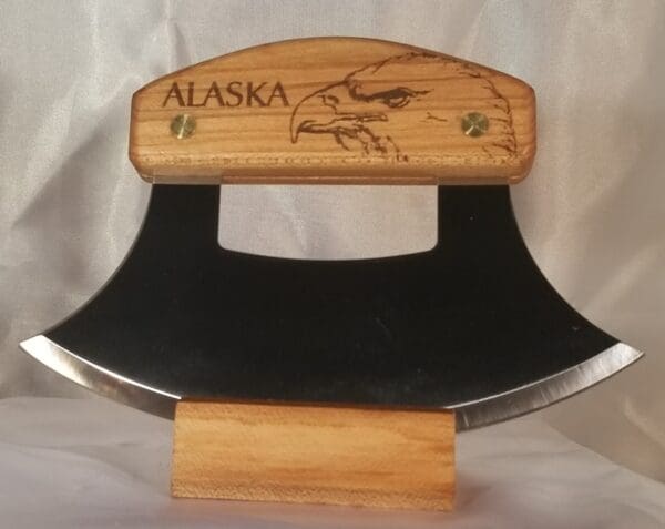 A wooden knife holder with the word alaska on it.