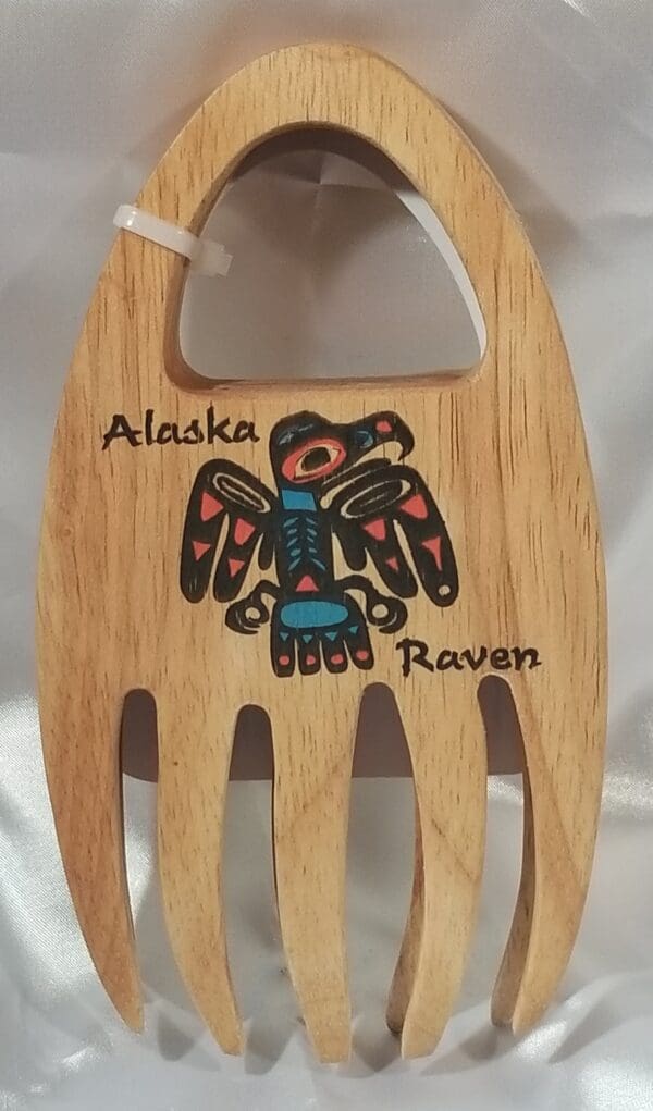 A wooden spoon with the Alaskan Grabbers logo on it.