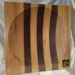 A wooden cutting board with three different colored stripes.