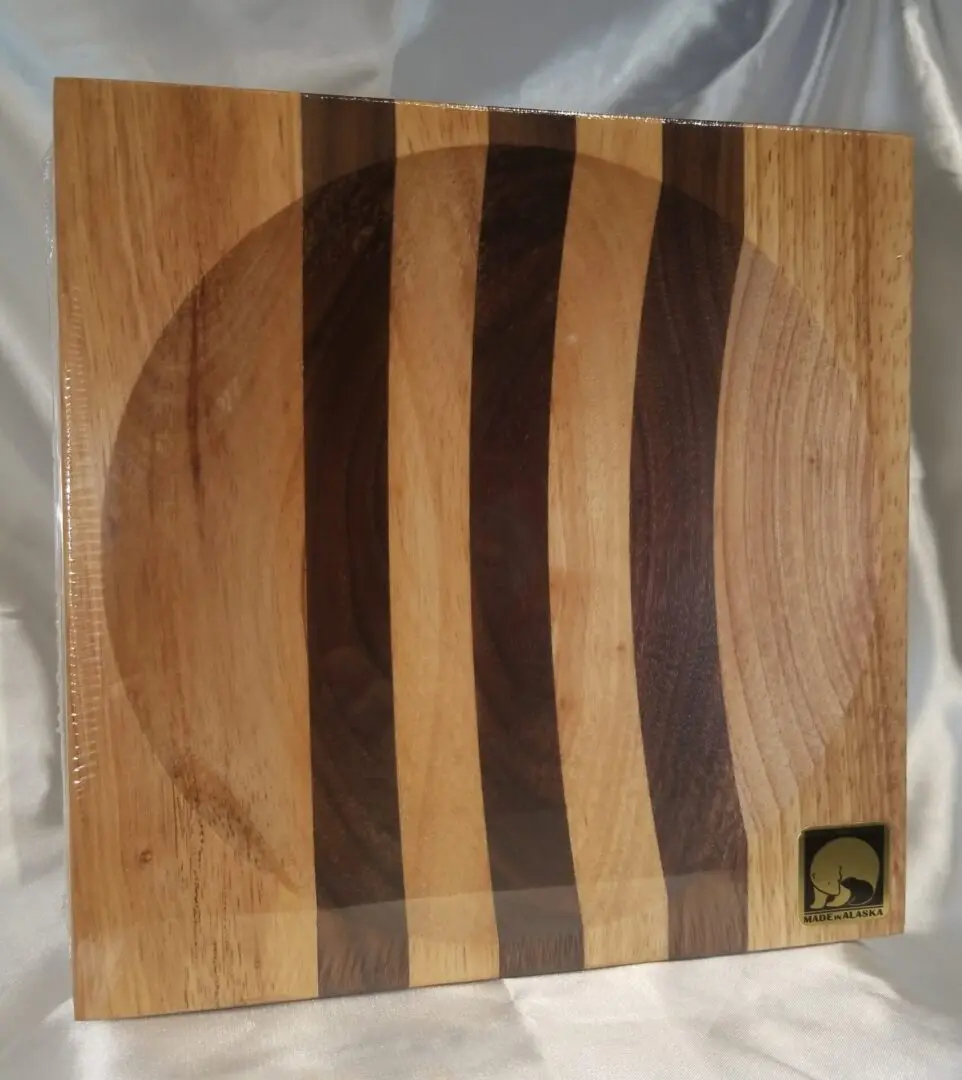 A wooden cutting board with three different colored stripes.