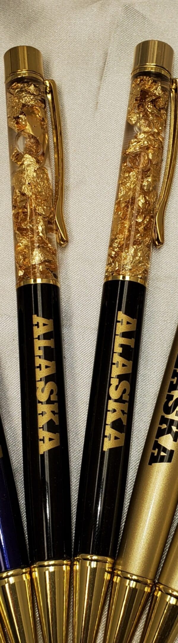 Two pens with gold leaf on top of them.