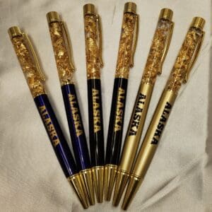 A group of pens with gold leaf on them.
