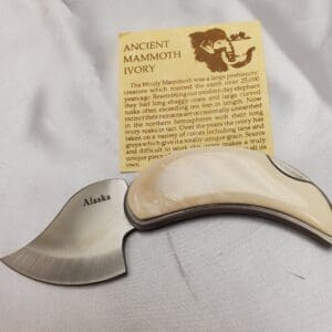 A small knife with a wooden handle and an ancient mammoth story card.
