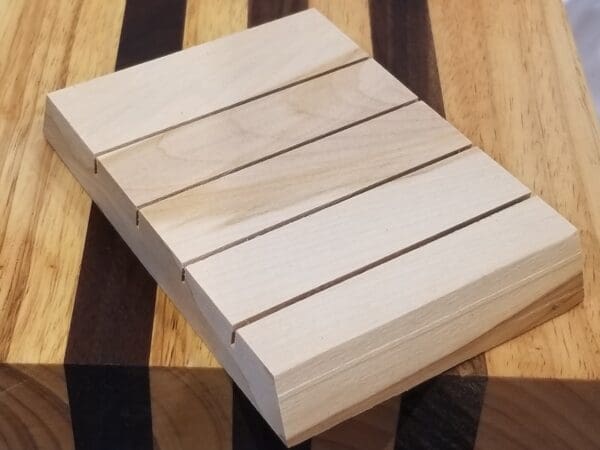 A wooden cutting board on top of a display/storage stand.