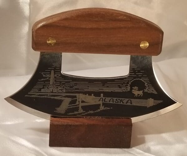 An Inupiat Puffin's and Pipeline Collection knife with an image of a ship on it.