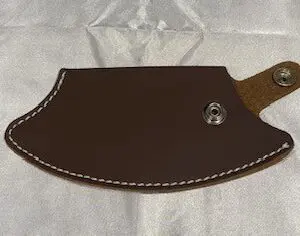 An Inupiat Style Leather Sheath knife holder on a white surface.
