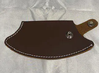 An Inupiat Style Leather Sheath knife holder on a white surface.