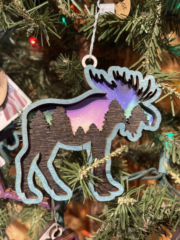 Moose ornament hanging on a christmas tree.