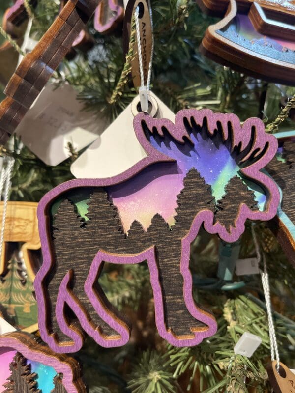 Moose ornaments hanging on a christmas tree.