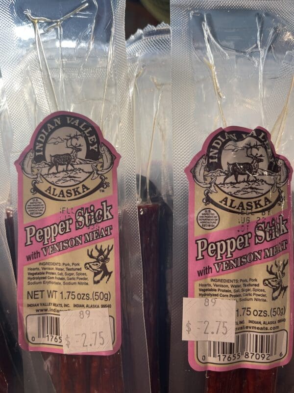 Two packages of pepper sticks are sitting on a table.